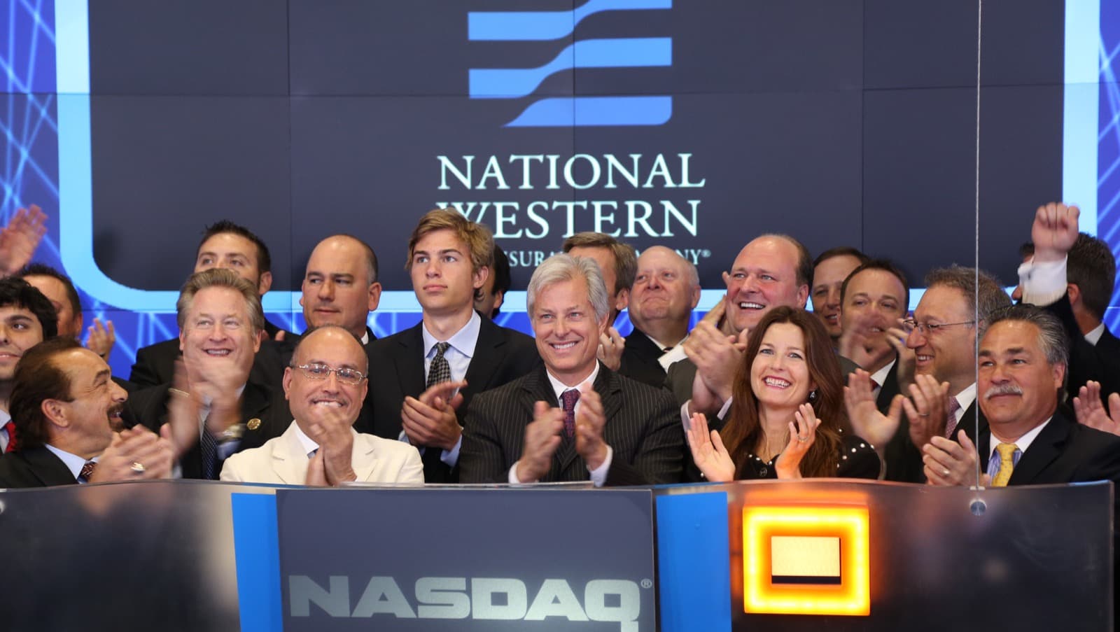 National Western Life Insurance team celebrating in front of the company logo.